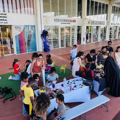 Animateur costumé entouré d'enfants lors d'un atelier en galerie commerciale à La Réunion