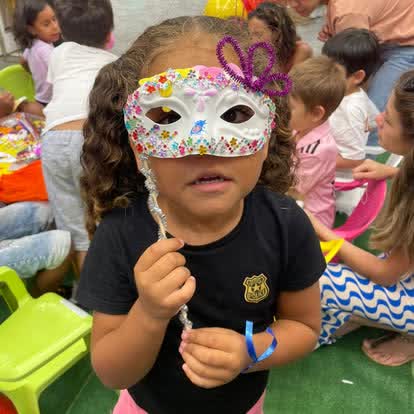 Enfant fier de son masque vénitien décoré lors d'un atelier créatif à La Réunion