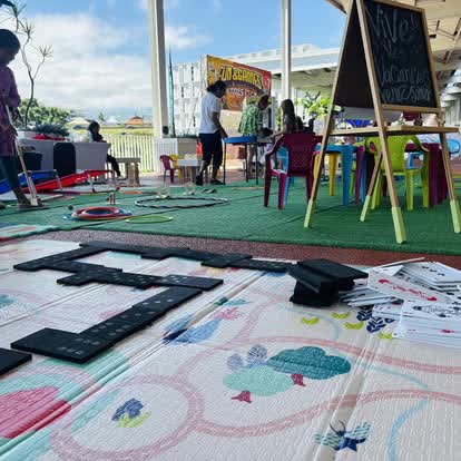 Espace enfants complet avec tapis et tableau installé dans une galerie commerciale de La Réunion