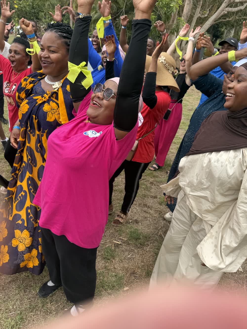 Participants bras levés pendant un jeu collectif lors d'une journée d'entreprise à Mayotte